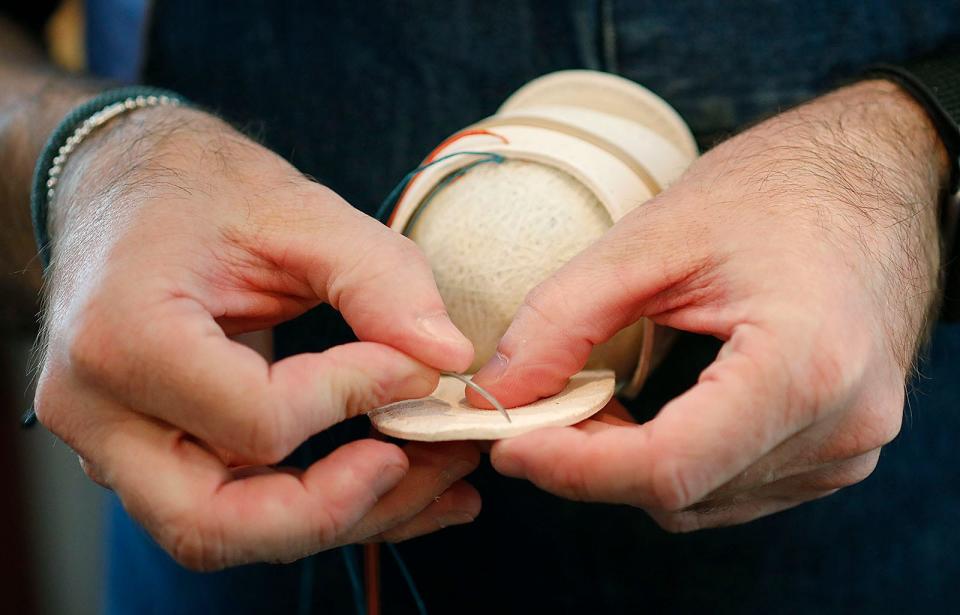 William Peebles makes baseballs, bats, wallets in the Norwell studio of Huntington Base Ball Co. The balls are hand stitched one at a time, some feature custom logos and others are replicas of the first balls used in the 1860's.