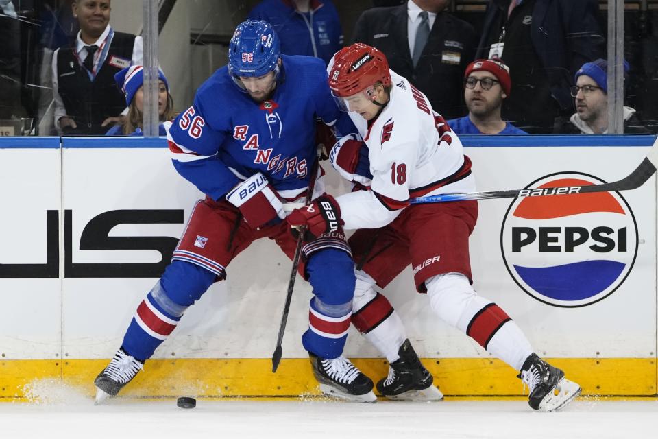 New York Rangers' Erik Gustafsson (56) fights for control of the puck with Carolina Hurricanes' Jack Drury (18) during the first period of an NHL hockey game Thursday, Nov. 2, 2023, in New York. (AP Photo/Frank Franklin II)