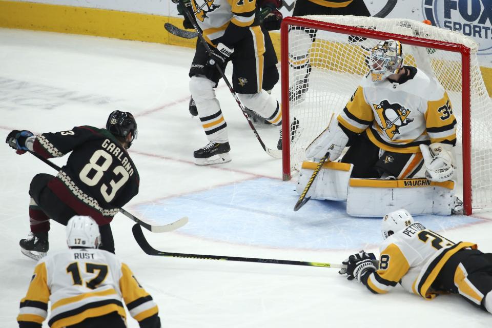 Arizona Coyotes right wing Conor Garland (83) scores a goal against Pittsburgh Penguins goaltender Tristan Jarry (35) as Penguins right wing Bryan Rust (17) and defenseman Marcus Pettersson, right, look on during the first period of an NHL hockey game Sunday, Jan. 12, 2020, in Glendale, Ariz. (AP Photo/Ross D. Franklin)