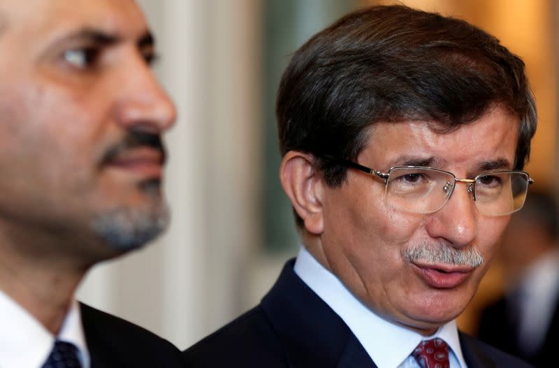 FILE PHOTO: Turkey's Foreign Minister Davutoglu speaks as the head of the opposition Syrian National Coalition Jarba listens in Istanbul