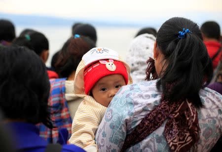 Villagers and relatives of missing passengers from a ferry accident at Lake Toba hold a prayer session at the pier of Tigaras port in Simalungun, North Sumatra, Indonesia, June 21, 2018. REUTERS/Beawiharta