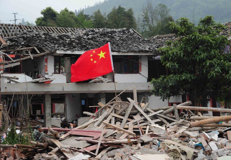 A Chinese national flag flies in the ruins of houses in Longmen, a town close to the epicentre of the earthquake that hit the city in Ya'an, Sichuan province, on April 21, 2013. The life of many in Longmen, and across the wider county of Lushan, changed forever when the devastating earthquake struck on Saturday morning, leaving more than 200 people dead or missing