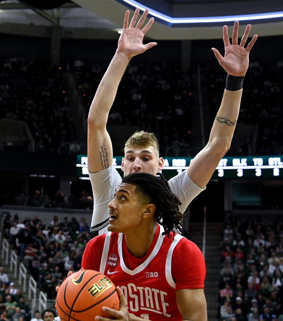 Ohio State Buckeyes forward Devin Royal (21) eyes the basket past Michigan State Spartans center Carson Cooper (15) during the first half at Breslin Center in East Lansing on Sunday, Feb. 25, 2024.