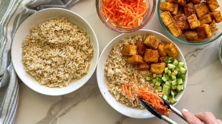 assembling rice bowls with tofu and vegetables