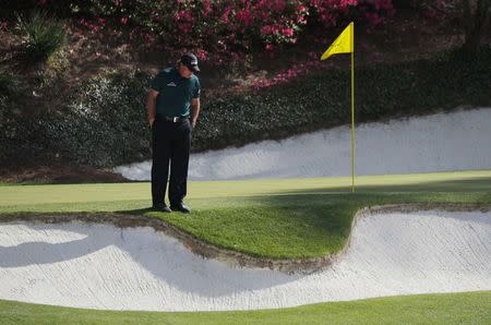 Phil Mickelson of the U.S. looks over his ball after hitting to the edge of a sand trap on the 12th hole during first round play of the 2018 Masters golf tournament at the Augusta National Golf Club in Augusta, Georgia, U.S., April 5, 2018. REUTERS/Brian Snyder