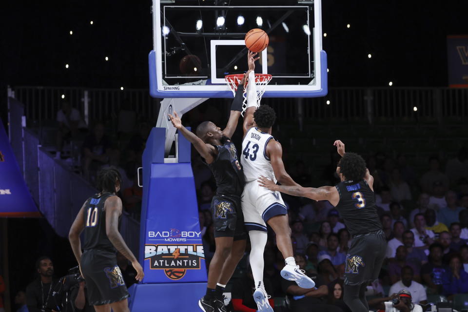 In a photo provided by Bahamas Visual Services, Villanova's Eric Dixon (43) goes for a layup between Memphis' David Jones (8) and Jordan Brown (3) during the first half of an NCAA college basketball game in the Battle 4 Atlantis at Paradise Island, Bahamas, Friday, Nov. 24, 2023. (Tim Aylen/Bahamas Visual Services via AP)
