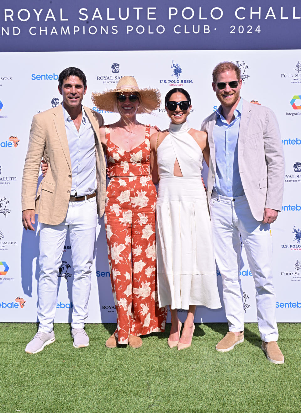 Meghan Markle attends the Sentebale charity polo match with Prince Harry while wearing a white cutout halter dress and nude pumps