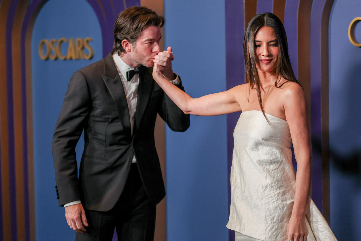 John Mulaney kisses Olivia Munn's hand at the Governors Awards