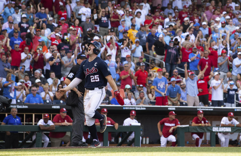 Mississippi's Tim Elko (25) celebrates as he runs toward home, as he was driven in by Kevin Graham against Oklahoma during the first inning during the first game of the NCAA College World Series finals, Saturday, June 25, 2022, in Omaha, Neb. (AP Photo/Rebecca S. Gratz)