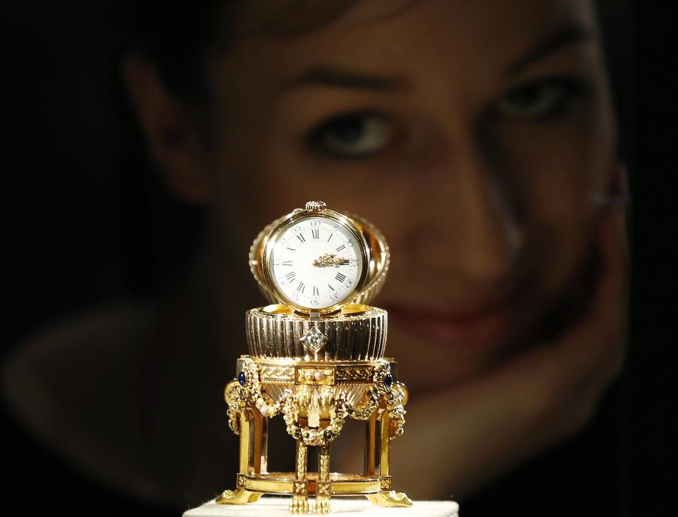 An assistant poses for a photograph with a Faberge egg during a photo-call at antique dealer Wartski, in central London