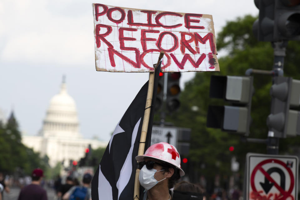 A demonstrator holds a placard, with the US Capitol in the background, during a march on Pennsylvania Ave against racism and police brutality, in Washington, DC on June 6, 2020. - Demonstrations are being held across the US following the death of George Floyd on May 25, 2020, while being arrested in Minneapolis, Minnesota. (Photo by Jose Luis Magana / AFP) (Photo by JOSE LUIS MAGANA/AFP via Getty Images)