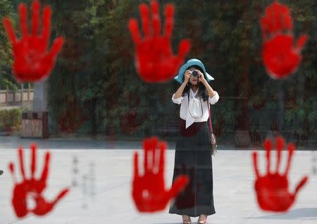 A visitor takes a picture of a display bearing hand prints of war heroes from the War of Resistance against Japan, at Jianchuan Museum Cluster in Anren, Sichuan Province, China, May 13, 2016. REUTERS/Kim Kyung-Hoon