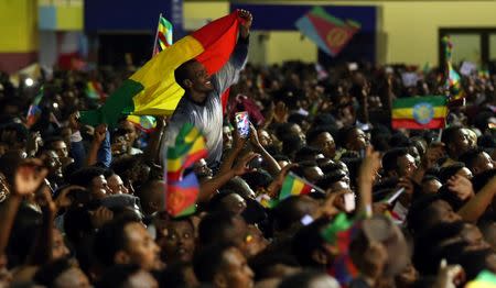 Residents wave the Ethiopian and Eritrean national flags as they dance during a concert at the Millennium Hall in Addis Ababa, Ethiopia July 15, 2018. REUTERS/Tiksa Negeri