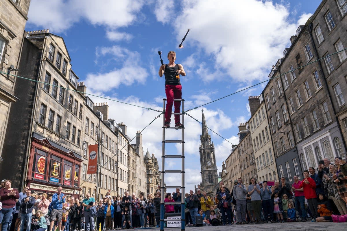 Street performers entertain the crowds on Edinburgh’s Royal Mile at Edinburgh Festival Fringe (Jane Barlow/PA) (PA Archive)