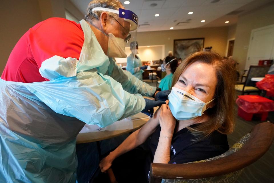 Health care worker Pam Peter, right, prepares to receive her second dose of COVID-19 vaccine last month in Pompano Beach, Fla. Medical workers and long-term care patients and staff were at the front of the line for inoculations.