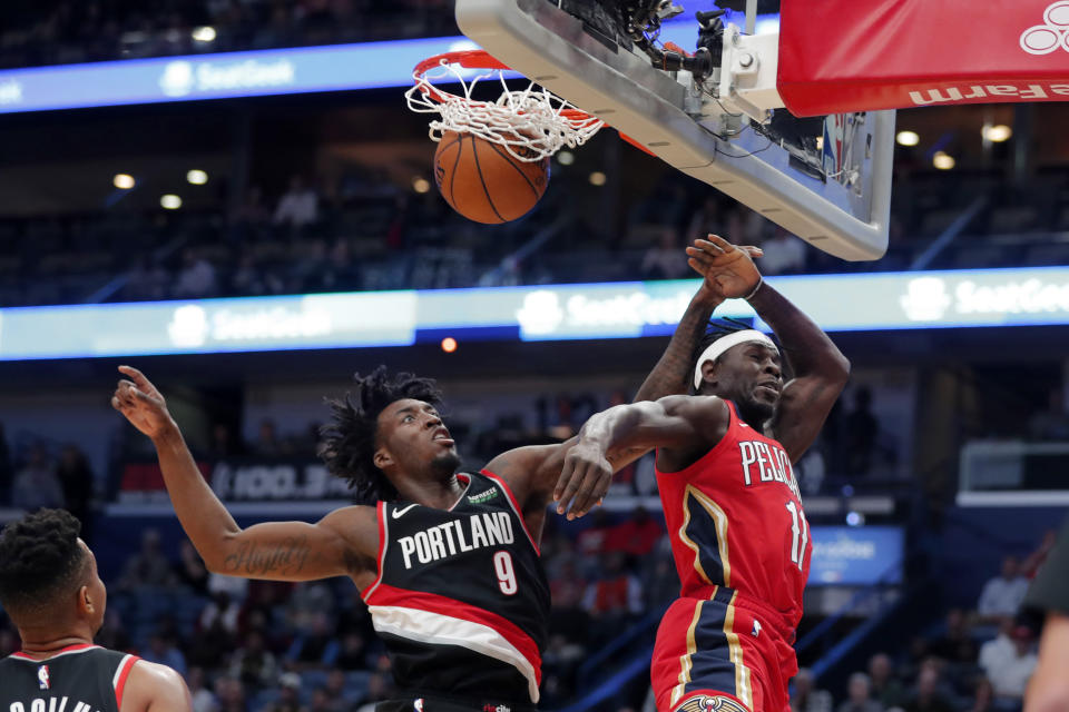 New Orleans Pelicans guard Jrue Holiday (11) slam dunks as he is fouled by Portland Trail Blazers forward Nassir Little (9) in the first half of an NBA basketball game in New Orleans, Tuesday, Nov. 19, 2019. (AP Photo/Gerald Herbert)