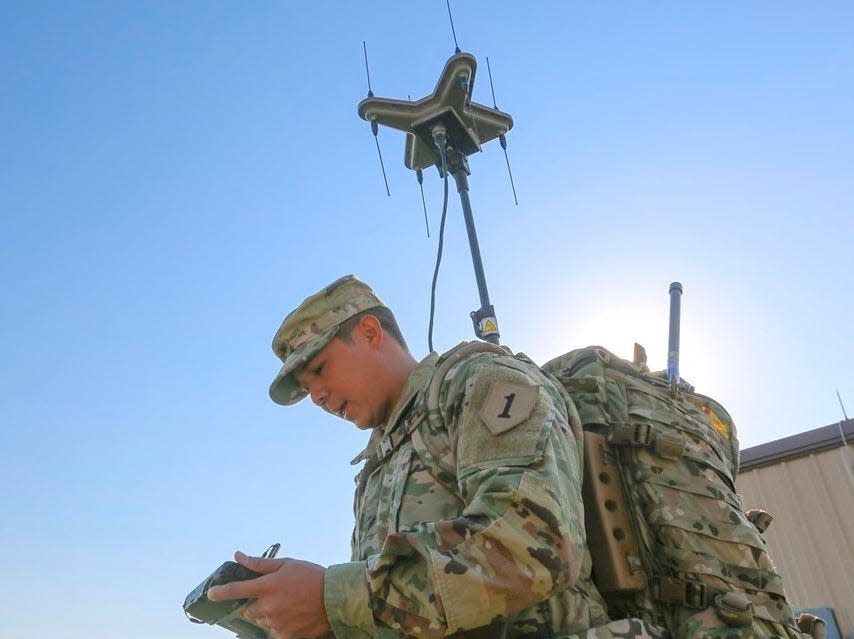 A soldier holding an electronic device.