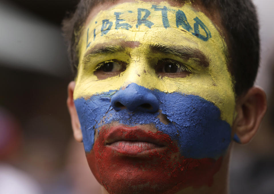 An opponent to Venezuela's President Nicolas Maduro, his face the colors of the Venezuelan national flag and the Spanish word for "Freedom" written on his forehead, takes part in a march in Caracas, Venezuela, Saturday, May 4, 2019. Opposition leader Juan Guaido took his quest to win over Venezuela's troops back to the streets, calling his supporters to participate in an outreach to soldiers outside military installations across the country. (AP Photo/Martin Mejia)