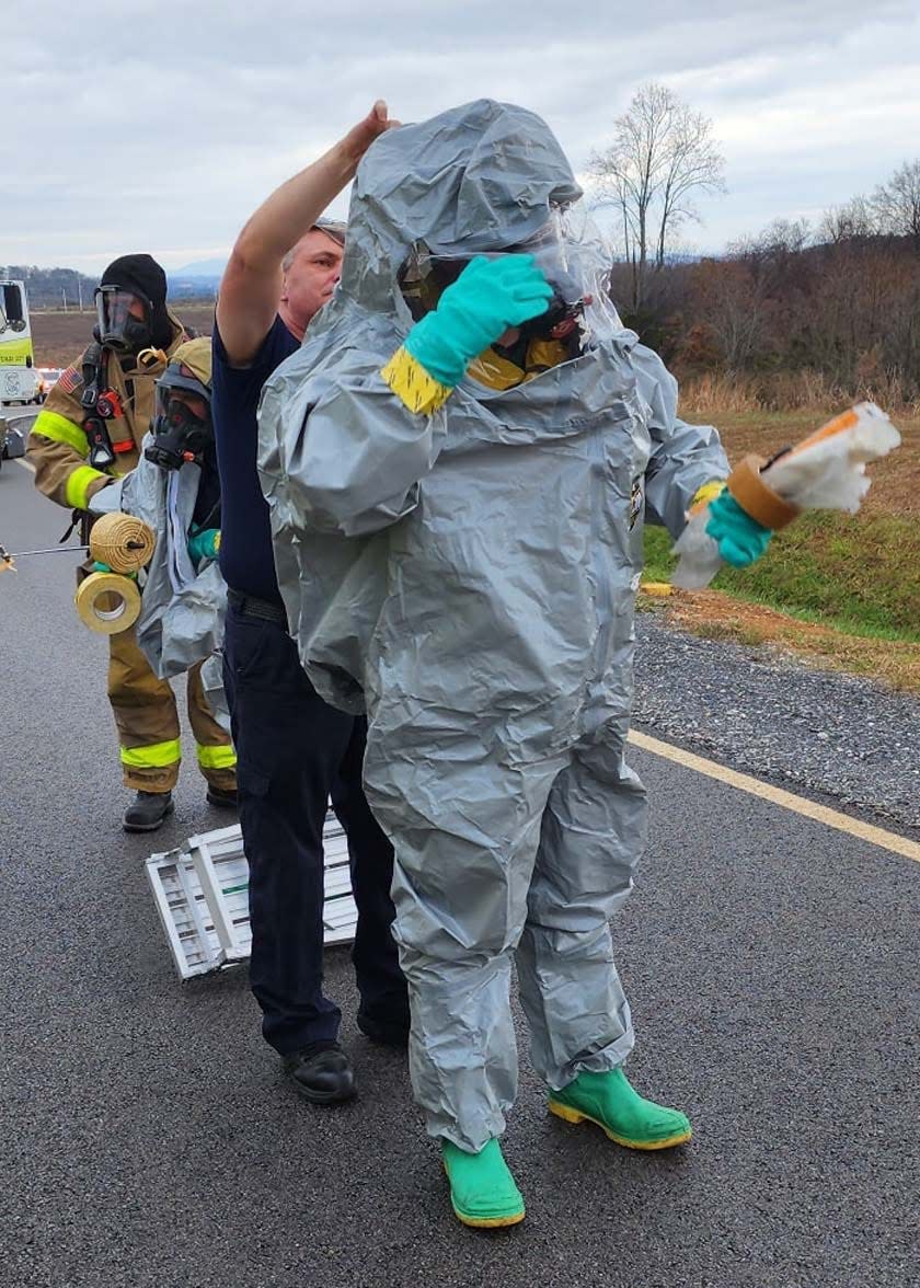Charles Wilson helps a firefighter on with a hazmat suit for Rural Metro Fire in this capture from his Facebook Timeline Nov. 25, 2022.