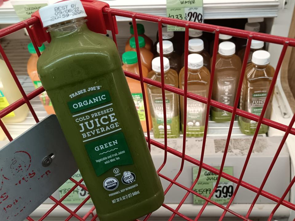 Bottle of cold-pressed green juice in red Trade Joe's cart