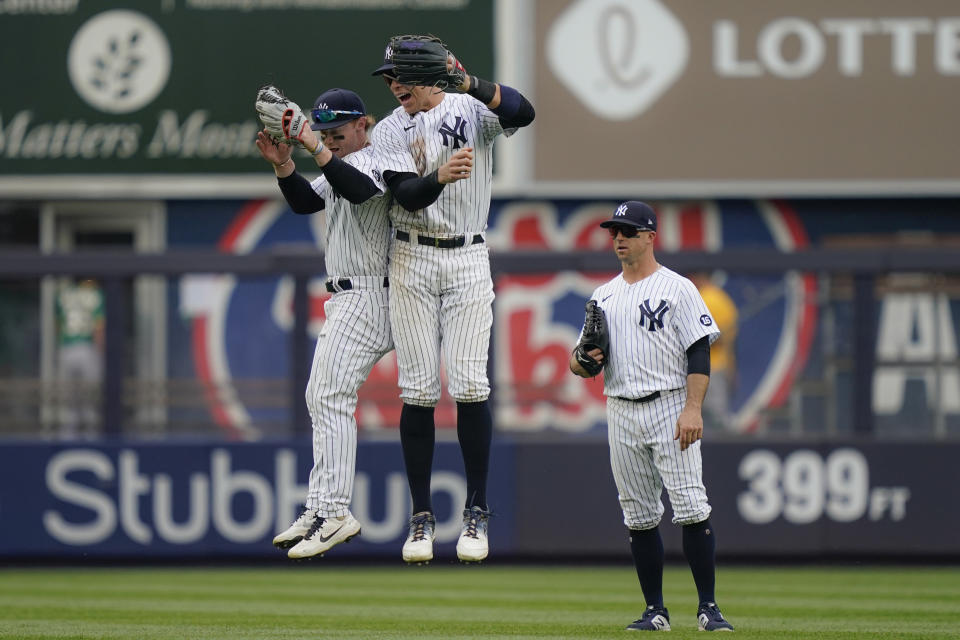 New York Yankees right fielder Aaron Judge, center, left fielder Clint Frazier, left, and left fielder Brett Gardner, right, celebrate after closing the ninth inning of a baseball game against the Oakland Athletics, Saturday, June 19, 2021, in New York. (AP Photo/John Minchillo)