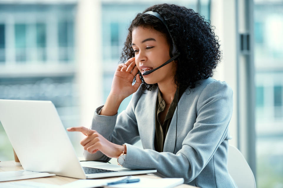 Woman wearing a headset in front of a laptop