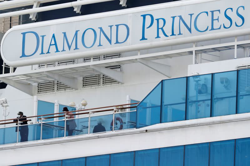 Passengers look out from a deck of the cruise ship Diamond Princess at Daikoku Pier Cruise Terminal in Yokohama, south of Tokyo, Japan