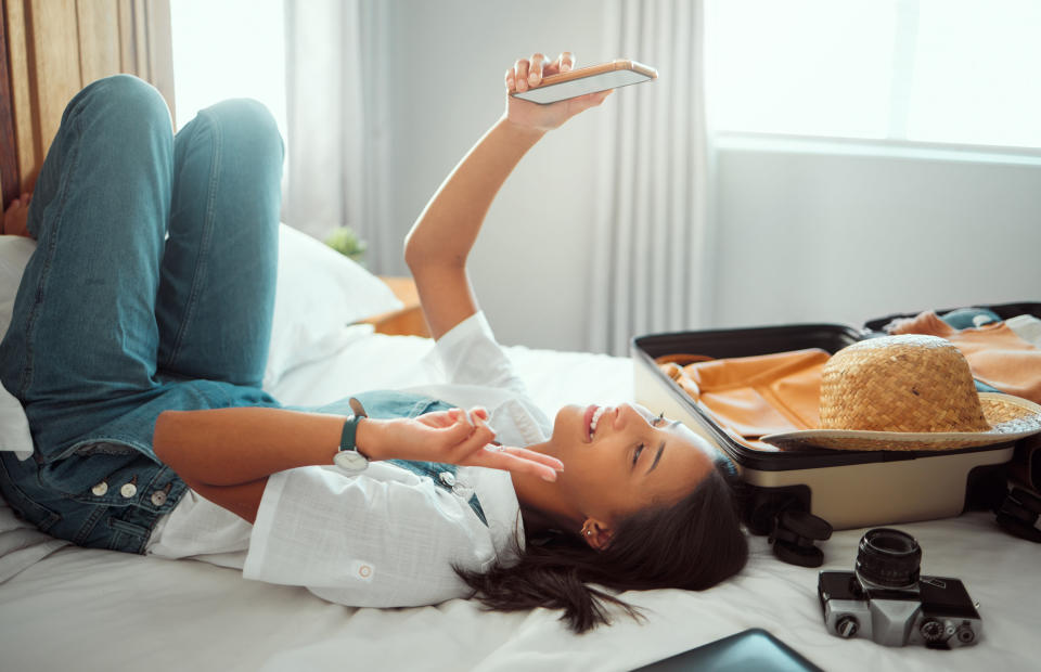 A woman laying in bed and taking a selfie