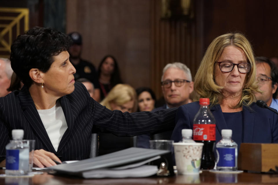 FILE - In this Thursday, Sept. 27, 2018 file photo, attorney Debra Katz reaches out to Christine Blasey Ford as she testifies before the Senate Judiciary Committee on Capitol Hill in Washington. On Wednesday, June 30, 2021, as the nation watched Bill Cosby released from prison, some worried it would have a chilling effect on survivors, who often don't come forward because they don't believe it will bring justice. And they wondered whether some of the movement’s momentum, already slowed by the pandemic, would be lost amid the feeling that another powerful man had gotten away with it — albeit on a technicality. (AP Photo/Andrew Harnik, Pool, File)