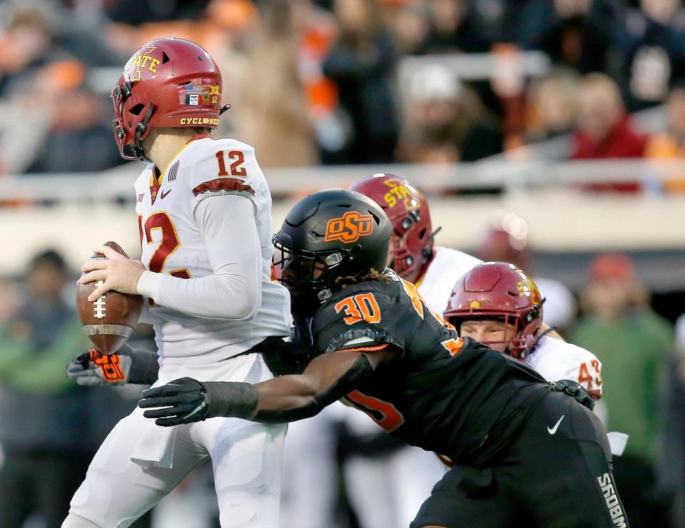 Nov 12, 2022; Stillwater, Oklahoma, USA;  Oklahoma State's Collin Oliver (30) sacks Iowa State's Hunter Dekkers (12) in the fourth quarterduring the college football game between the Oklahoma State Cowboys (OSU) and the Iowa State Cyclones at Boone Pickens Stadium. OSU won 20-14. Mandatory Credit: Sarah Phipps-USA TODAY Sports