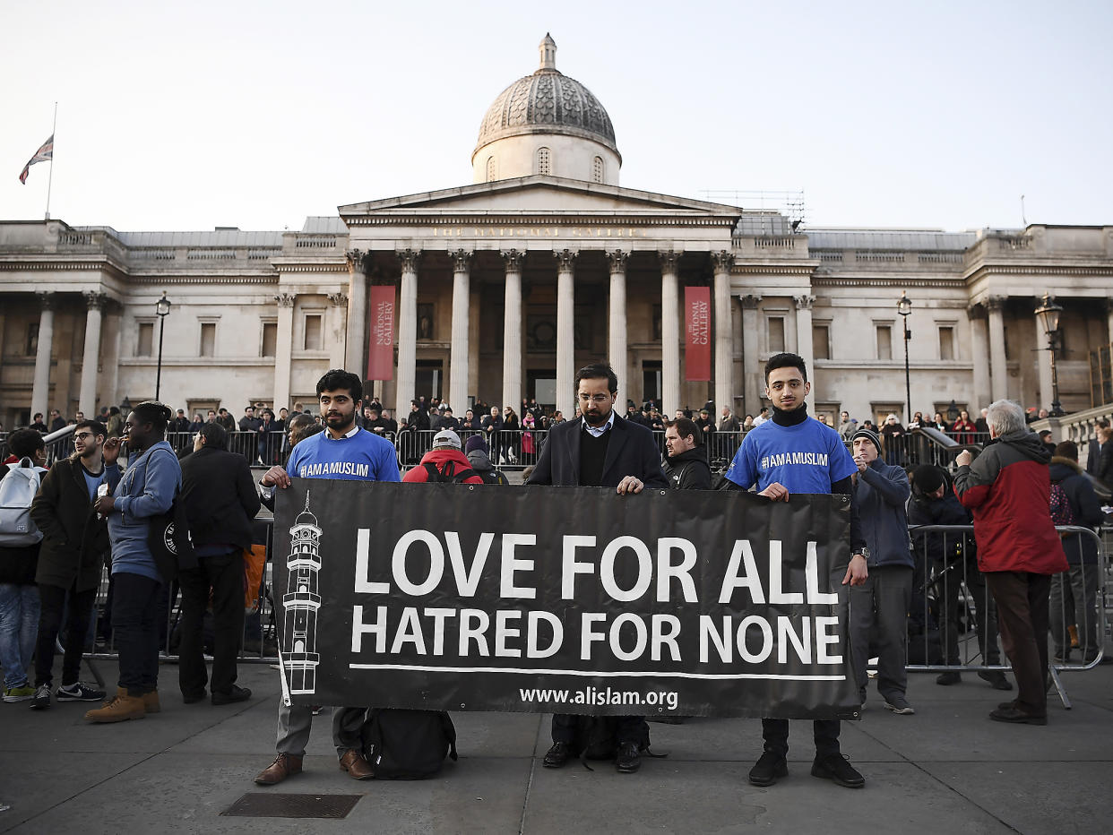 People hold up a banner ahead of a candlelit vigil at Trafalgar Square: Getty