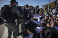 Israeli police officers clash with ultra-Orthodox Jews in Ashdod, Israel, Sunday, Jan. 24, 2021. Ultra-Orthodox demonstrators clashed with Israeli police officers dispatched to close schools in Jerusalem and Ashdod that had opened in violation of coronavirus lockdown rules, on Sunday. (AP Photo/Oded Balilty)