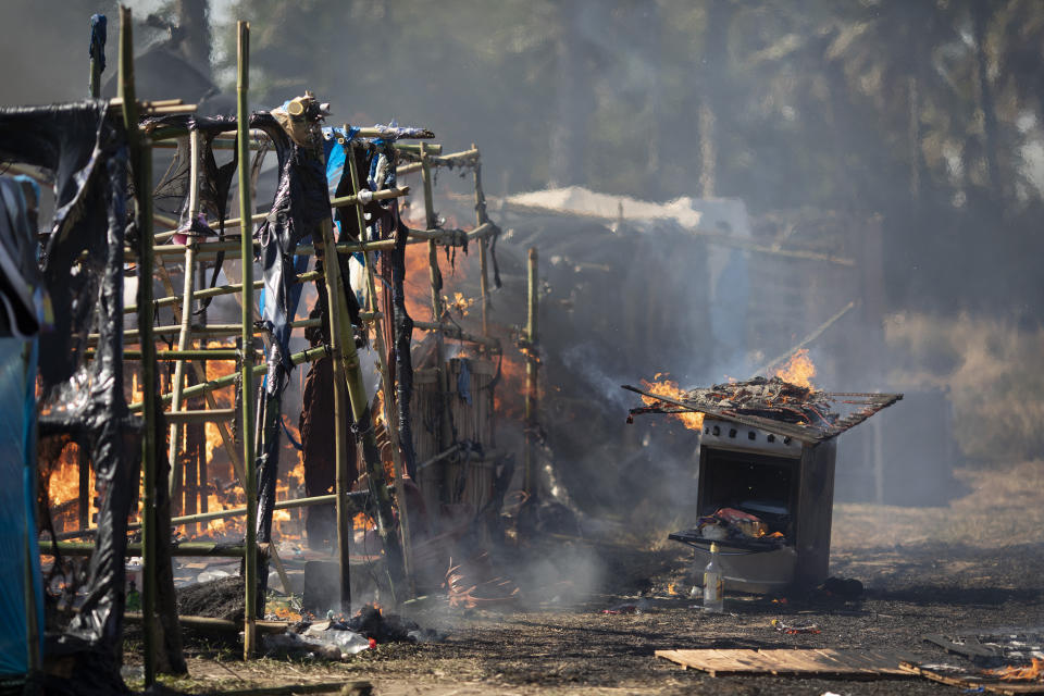 Squatters homes and are destroyed by fire caused by stoves that were left unattended during an eviction at a settlement coined the "First of May Refugee Camp," named for the date people moved on the land designated for a Petrobras refinery in Itaguai, Rio de Janeiro state, Brazil, Thursday, July 1, 2021, amid the new coronavirus pandemic. (AP Photo/Silvia Izquierdo)