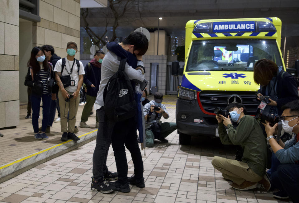 A relative and a friend of one of the 47 pro-democracy activists hug each other outside a court in Hong Kong, Thursday, March 4, 2021. A Hong Kong court on Thursday remanded all 47 pro-democracy activists charged under a Beijing-imposed national security law in custody, ending a four-day marathon court hearing. (AP Photo/Vincent Yu)