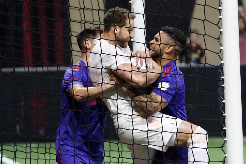 Atlanta United attacker Dom Dwyer, right, fights for the ball against a Columbus Crew player, center, after scoring his team's first goal, during the second half of an MLS soccer match in Atlanta, Saturday, May 28, 2022. (Miguel Martinez/Atlanta Journal-Constitution via AP)