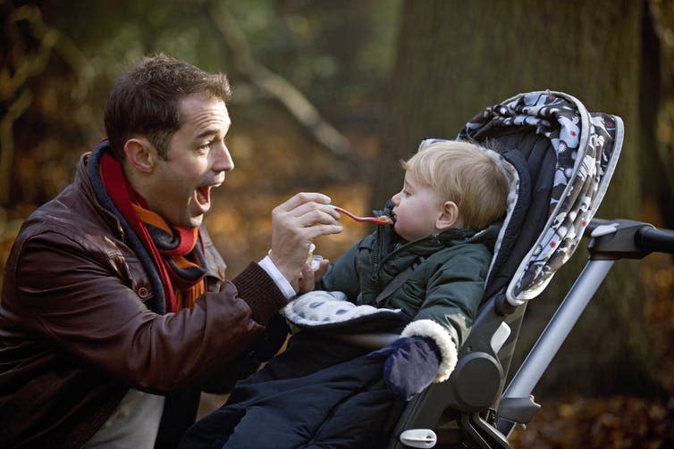 <span class="caption">Feeding themselves allows babies to be more in control of the pace and amount they eat.</span> <span class="attribution"><a class="link " href="https://www.shutterstock.com/image-photo/young-father-feeding-his-son-park-408647689" rel="nofollow noopener" target="_blank" data-ylk="slk:Air Images/Shutterstock;elm:context_link;itc:0;sec:content-canvas">Air Images/Shutterstock</a></span>