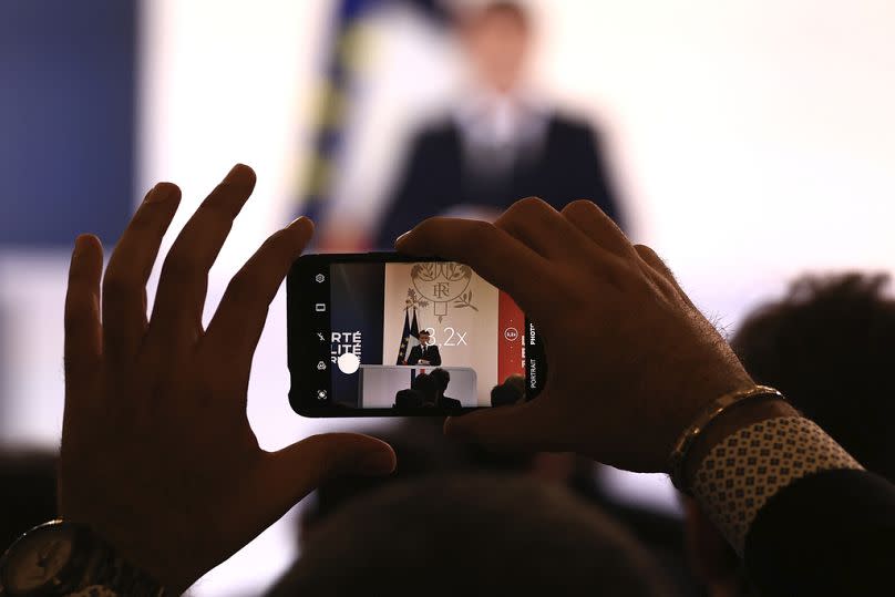 Un journaliste prend une photo du président français Emmanuel Macron mardi 16 janvier 2024 au palais de l'Élysée à Paris.