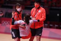 <p>Japan's right back Yui Sunami (C) is carried after being injured during the women's preliminary round group A handball match between Japan and Montenegro of the Tokyo 2020 Olympic Games at the Yoyogi National Stadium in Tokyo on July 27, 2021. (Photo by Daniel LEAL-OLIVAS / AFP)</p> 