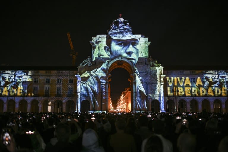 Unas fotografías de la Revolución de los Claveles tomadas por el fotoperiodista Alfredo Cunha se proyectan en el arco de la Rua Augusta, en la plaza del Comercio de Lisboa, el 24 de abril de 2024 (Patricia de Melo Moreira)