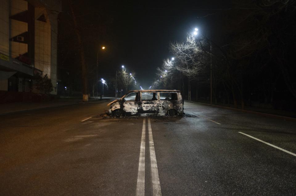 A police bus, which was burned after clashes, remains in an empty street in Almaty, Kazakhstan, late Saturday, Jan. 8, 2022. The office of Kazakhstan's president says about 5,800 people were detained by police during protests that burst into violence last week and prompted a Russia-led military alliance to send troops to the country. (AP Photo/Vasily Krestyaninov)