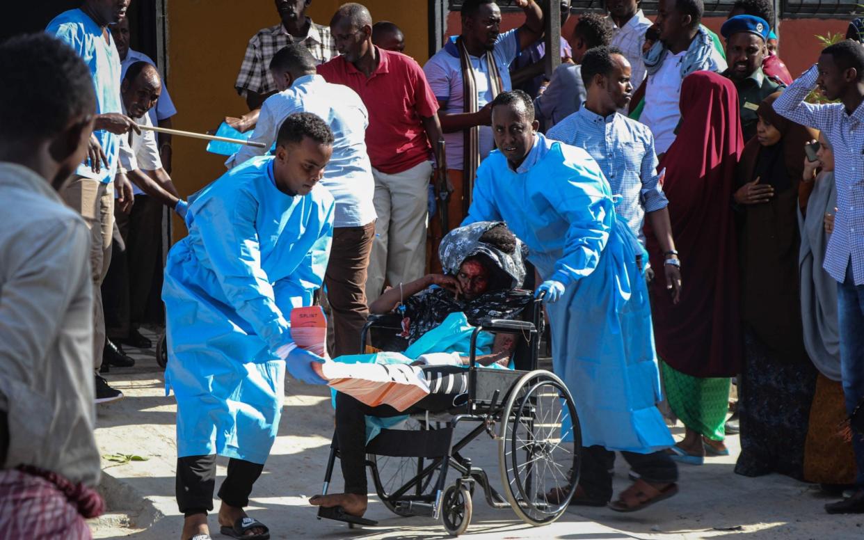 A woman that was wounded during the bombing attack is pushed on a wheel chair at the Madina Hospital in Mogadishu - AFP