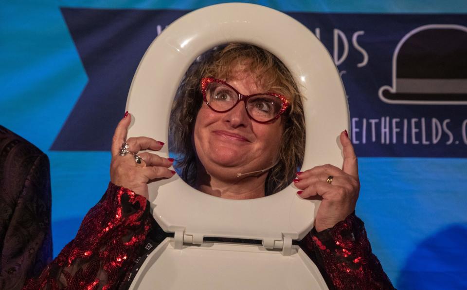 A shadow of Sarah Harfield, aka Lady Sarah, holds a toilet seat near her face for a magic trick during the Magic Soiree inside Camp Ticonderoga in Troy on Saturday, Sept. 30, 2023.