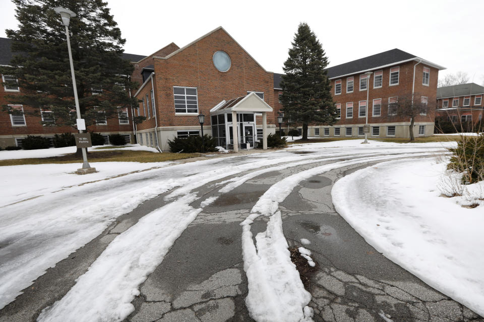 FILE - In this March 12, 2019 file photo, an ice and snow covered road leads up to the main building on the Veterans Affairs campus, Tuesday, March 12, 2019, in Knoxville, Iowa. After watching for more than a decade as a once busy Veterans Affairs campus deteriorated into a sprawling ghost town, leaders of a small Iowa city announced plans to take control of the property and likely demolish most of the structures. City and county officials signed documents Wednesday, Jan. 15, 2020, taking ownership of the 153-acre property. (AP Photo/Charlie Neibergall, File)