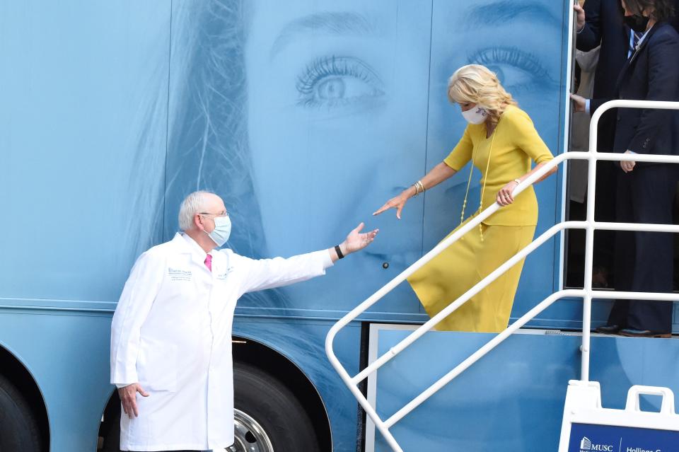 Dr. Raymond DuBois, MUSC Hollings Cancer Center director, left, extends a hand to first lady Jill Biden as she exits a mobile mammography unit during a tour of the facility on Monday, Oct. 25, 2021, in Charleston, S.C. (AP Photo/Meg Kinnard)