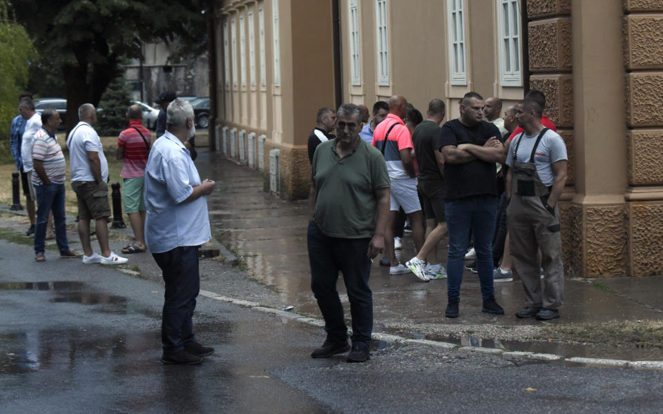 REMOVES SPECIFIC NUMBER OF CASUALTIES AND CLARIFIES SHOOTING DETAILS People stand on the site of the attack in Cetinje, some 30 km west of Podgorica, Montenegro, Friday, Aug. 12, 2022. A man went on a shooting rampage in the streets of a western Montenegro city Friday, killing multiple people, before being shot dead by a passerby, officials said. (AP Photo/Risto Bozovic)