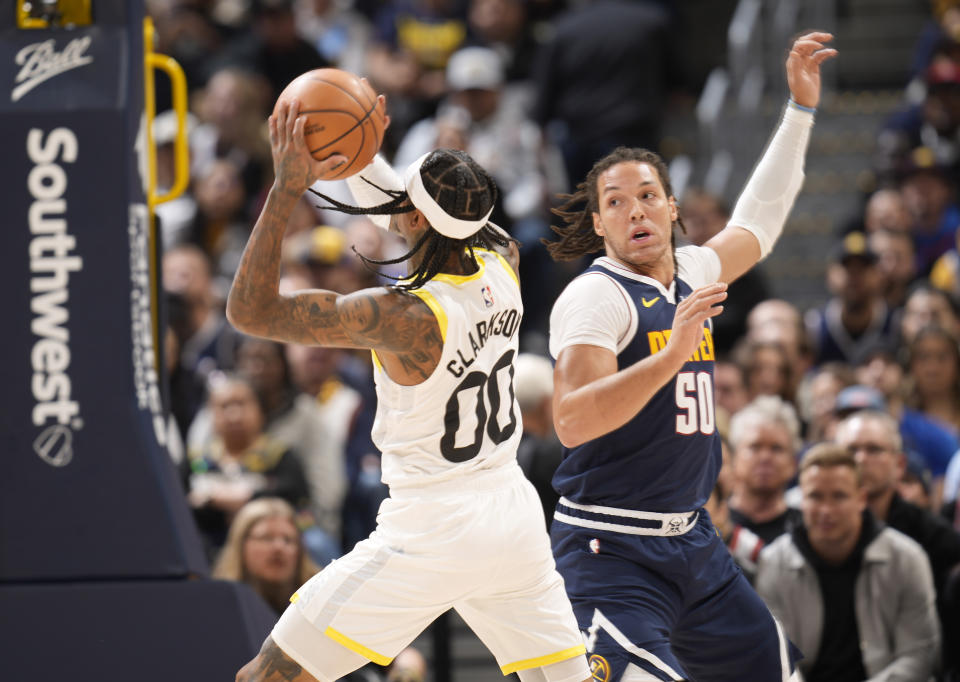 Utah Jazz guard Jordan Clarkson, left, drives past Denver Nuggets forward Aaron Gordon (50) in the first half of an NBA basketball game Monday, Oct. 30, 2023, in Denver. (AP Photo/David Zalubowski)