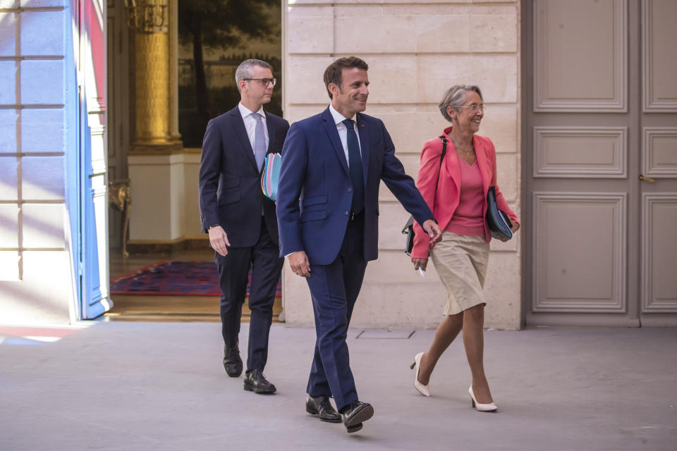 French President Emmanuel Macron, center, and Prime Minister Elisabeth Borne, right, arrive to attend the first cabinet meeting with new ministers at the Elysee Palace in Paris, Monday, July 4, 2022. French President Emmanuel Macron rearranged his Cabinet on Monday in an attempt to adjust to a new political reality following legislative elections in which his centrist alliance failed to win a majority in the parliament. (Christophe Petit Tesson, Pool via AP)