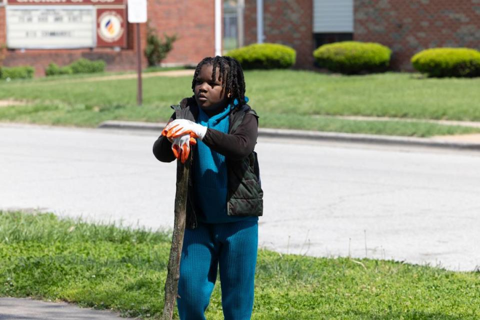 Donald Roberson IV rests on a stick while helping out during an Earth Day cleanup of East St. Louis on April 20, 2024.