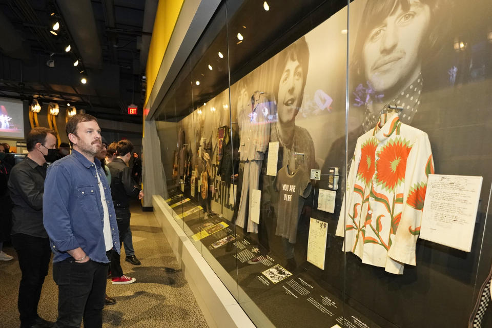 Caleb Followill looks at a Beatles display at the Rock and Roll Hall of Fame Thursday, April 29, 2021, in Cleveland. Rockers Kings of Leon tour a new digital exhibit at the Rock and Roll Hall of Fame for the NFT (cryptocurrency) launching before the rock band plays at the NFL draft, Thursday, April 29, 2021, in Cleveland. (AP Photo/Tony Dejak)