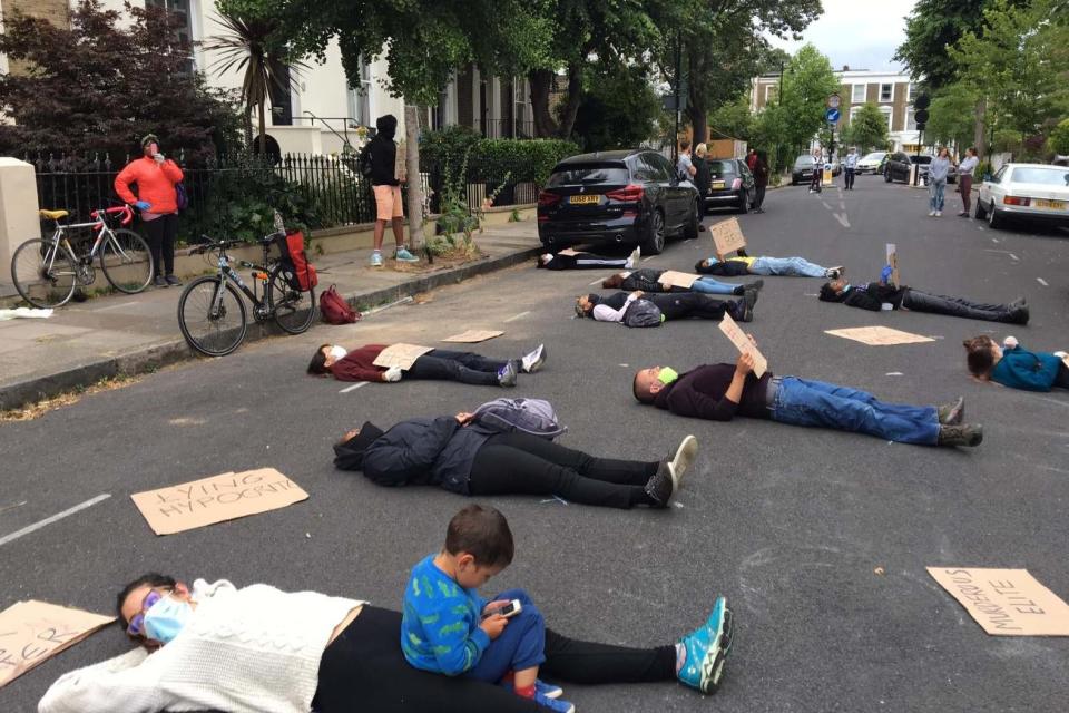 Some 20 protesters lay in the street outside the chief adviser's home in north London (PA)